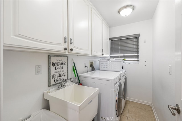 washroom featuring sink, cabinets, washing machine and dryer, and light tile patterned flooring