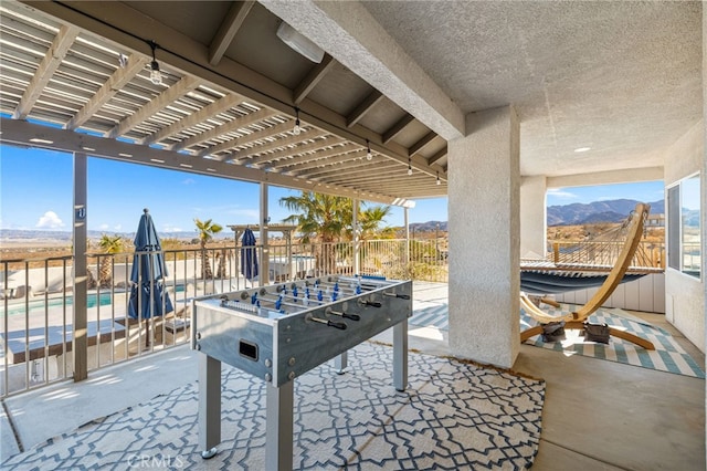 view of patio featuring a fenced in pool, a pergola, and a mountain view