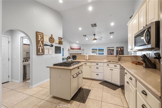 kitchen with appliances with stainless steel finishes, sink, light tile patterned floors, a kitchen island, and ceiling fan