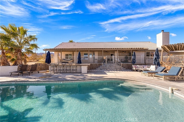 view of swimming pool with a bar and a patio