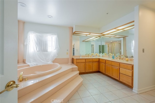 bathroom with a washtub, tile patterned floors, and vanity