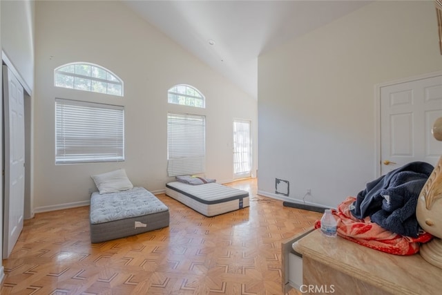 sitting room with high vaulted ceiling and light parquet flooring