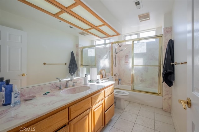 full bathroom featuring toilet, tile patterned flooring, vanity, and enclosed tub / shower combo