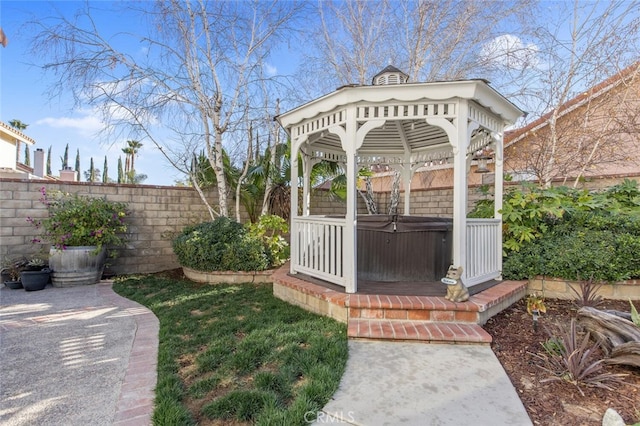 view of yard featuring a hot tub, fence, and a gazebo