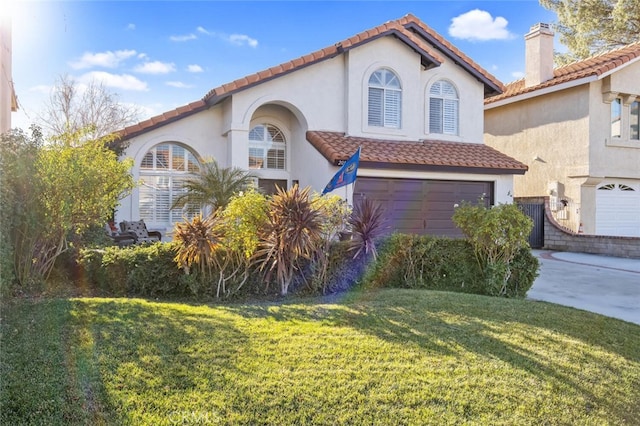 mediterranean / spanish house featuring a tile roof, concrete driveway, and a front yard