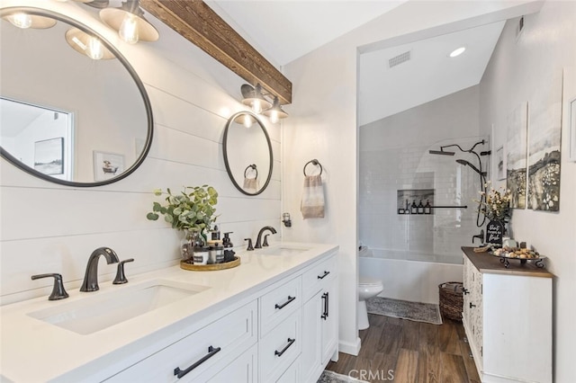 full bathroom featuring toilet, wood finished floors, a sink, shower / bathing tub combination, and double vanity