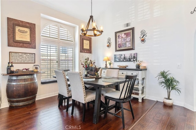 dining area featuring dark wood-style floors, a chandelier, visible vents, and baseboards