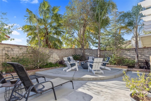 view of patio with a fenced backyard and a fire pit