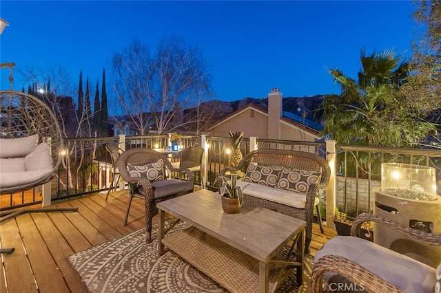 deck at night featuring a mountain view