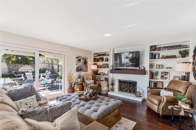 living area with a fireplace, dark wood finished floors, and built in features