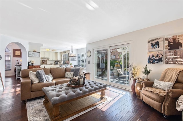 living room featuring dark wood-style floors and arched walkways