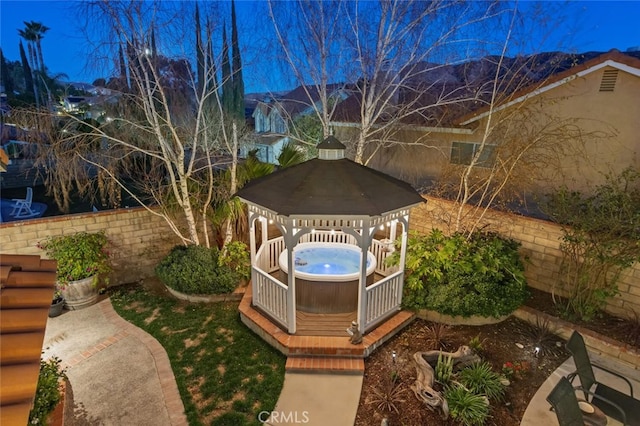 view of yard with a fenced backyard, a hot tub, a gazebo, and a wooden deck