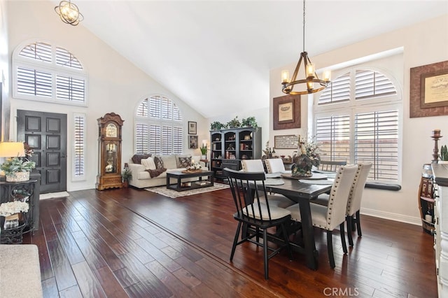 dining space with a chandelier, high vaulted ceiling, dark wood finished floors, and baseboards