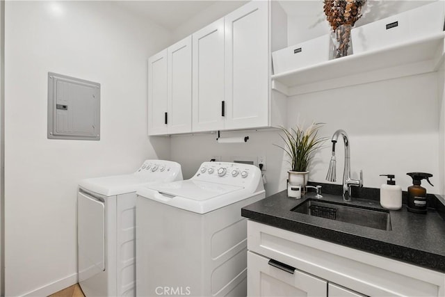 washroom featuring electric panel, cabinets, washing machine and clothes dryer, and sink