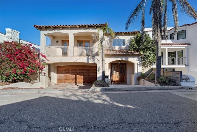 mediterranean / spanish-style home with a balcony and a garage