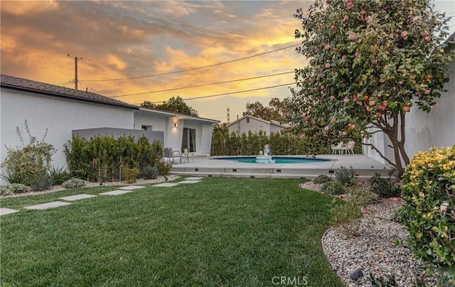 yard at dusk featuring a patio