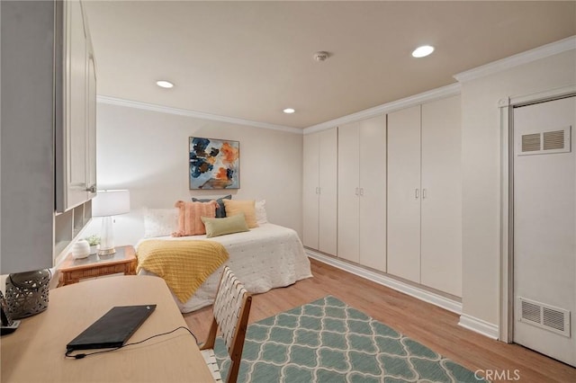 bedroom featuring light hardwood / wood-style floors and crown molding