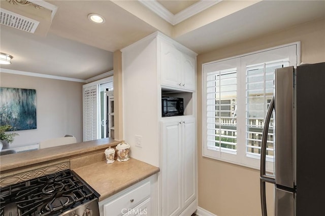 kitchen with white cabinets, ornamental molding, and appliances with stainless steel finishes