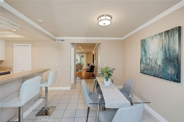 dining room with ornamental molding and light tile patterned flooring