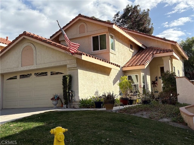 mediterranean / spanish-style house with a garage and a front lawn