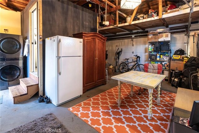 basement with white refrigerator and stacked washer and dryer