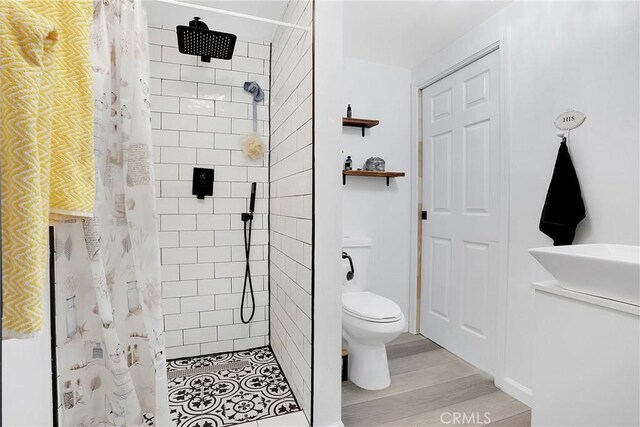 bathroom featuring a shower with curtain, hardwood / wood-style flooring, and toilet