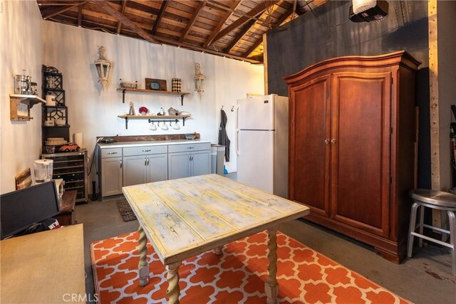 kitchen with white refrigerator, lofted ceiling with beams, and wood ceiling