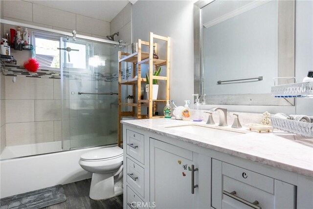 full bathroom featuring vanity, toilet, and combined bath / shower with glass door