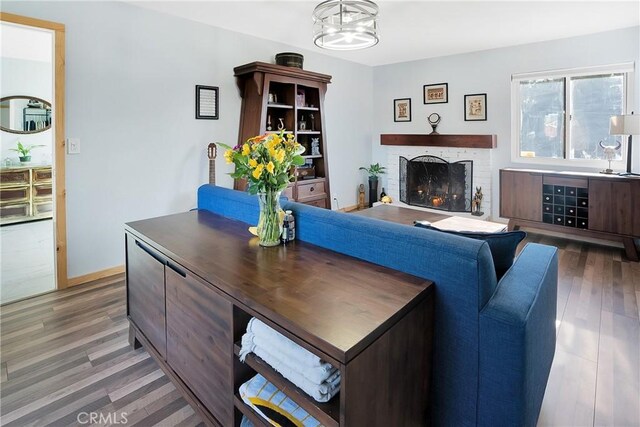 living room with hardwood / wood-style floors and a brick fireplace