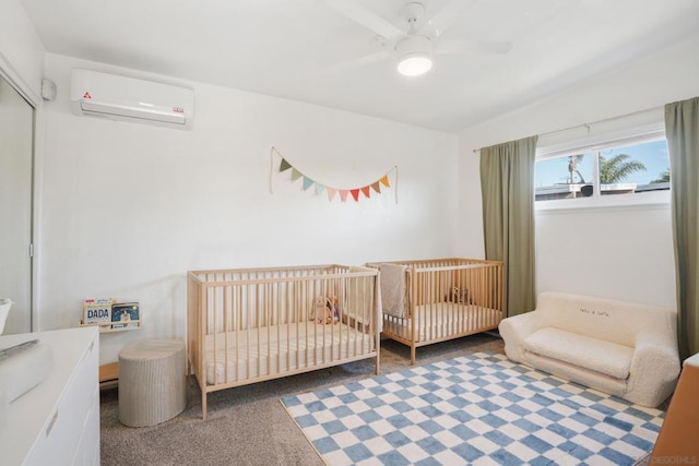 bedroom featuring a wall unit AC, ceiling fan, a crib, and carpet flooring