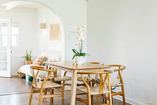 dining area with hardwood / wood-style floors and beamed ceiling