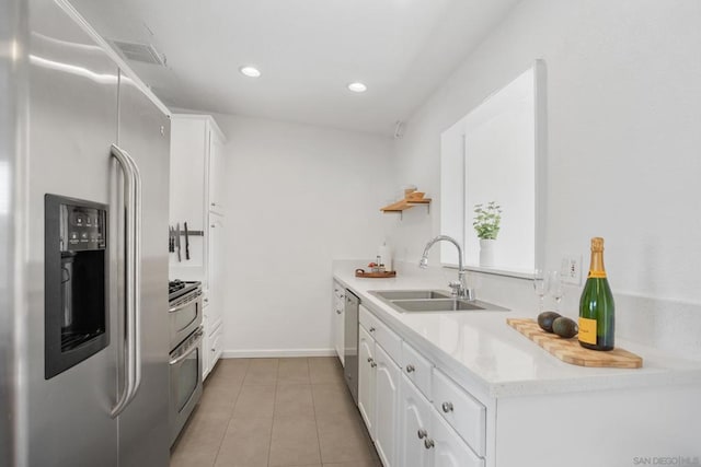 kitchen with sink, stainless steel appliances, white cabinets, and tile patterned flooring