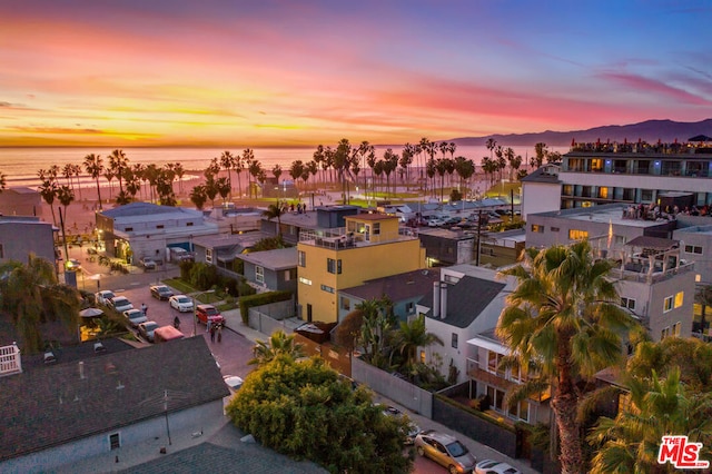 aerial view at dusk featuring a water view