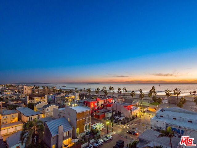 aerial view at dusk featuring a water view