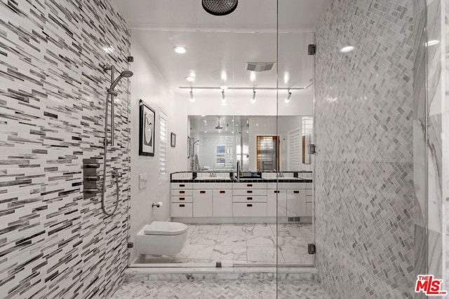 bathroom with toilet, a shower with door, vanity, and tile walls