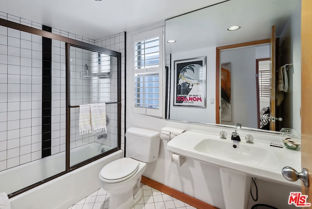 bathroom featuring toilet, tile patterned floors, and enclosed tub / shower combo