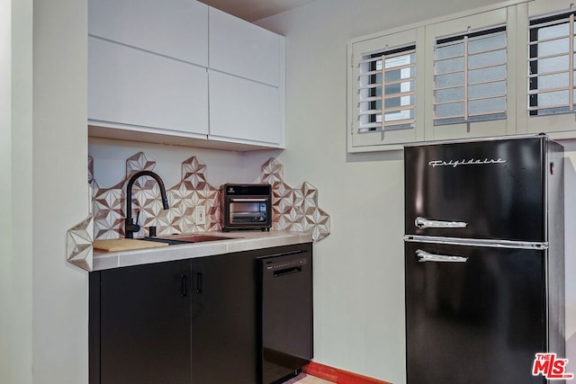 kitchen featuring decorative backsplash, sink, white cabinetry, and black appliances