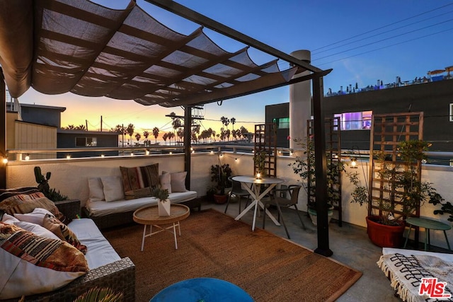 patio terrace at dusk with an outdoor hangout area and a pergola