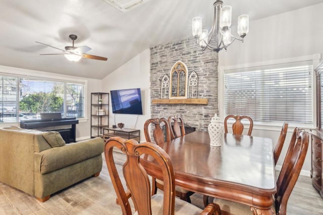 dining room featuring light hardwood / wood-style floors, vaulted ceiling, and ceiling fan with notable chandelier