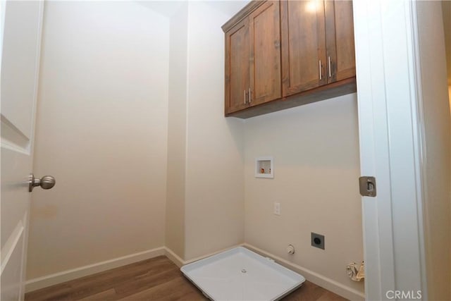 clothes washing area featuring dark wood-type flooring, cabinets, washer hookup, hookup for an electric dryer, and hookup for a gas dryer