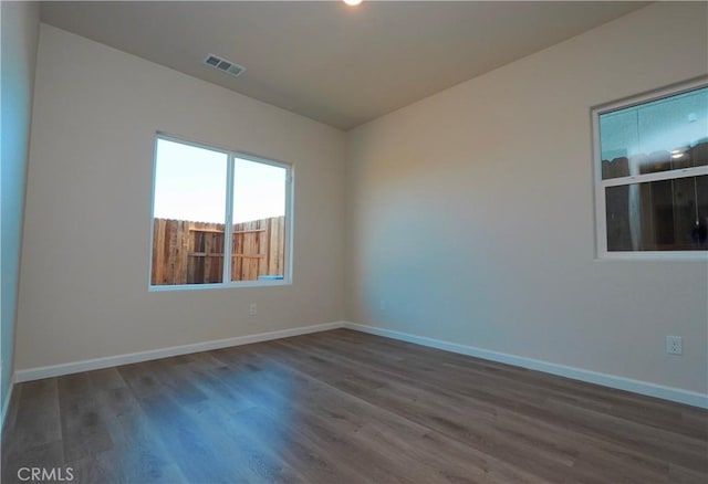 unfurnished room with dark wood-type flooring