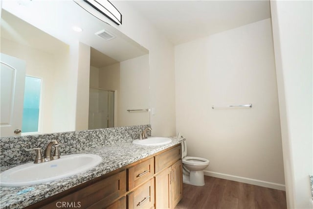 bathroom featuring hardwood / wood-style flooring, vanity, toilet, and walk in shower