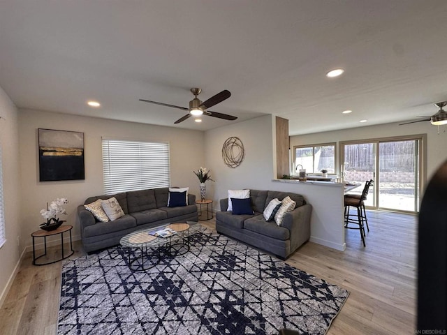 living room featuring light wood-type flooring and ceiling fan