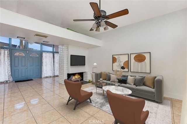 tiled living room with ceiling fan and a fireplace