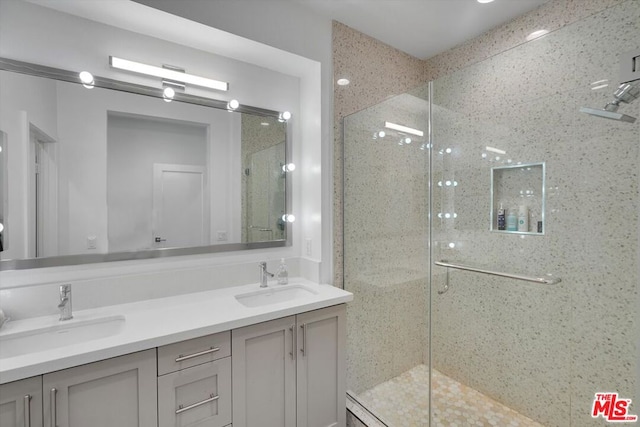 bathroom featuring a shower with door and vanity