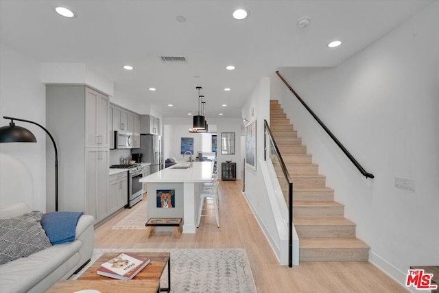 living room with light hardwood / wood-style floors and sink