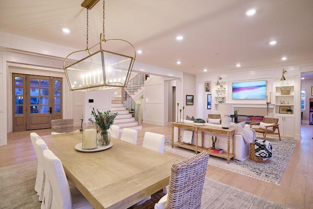 dining space featuring built in shelves and light hardwood / wood-style floors