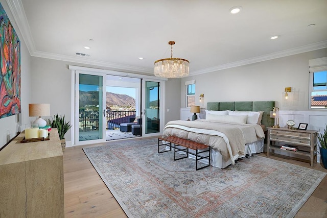 bedroom featuring ornamental molding, a notable chandelier, light hardwood / wood-style floors, and access to exterior