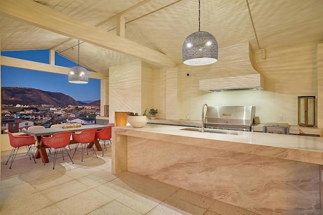 kitchen featuring sink, decorative light fixtures, high vaulted ceiling, and a mountain view