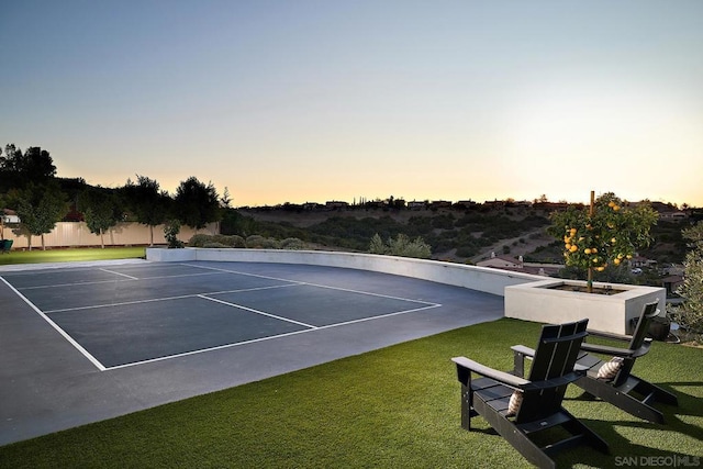 view of sport court with a lawn